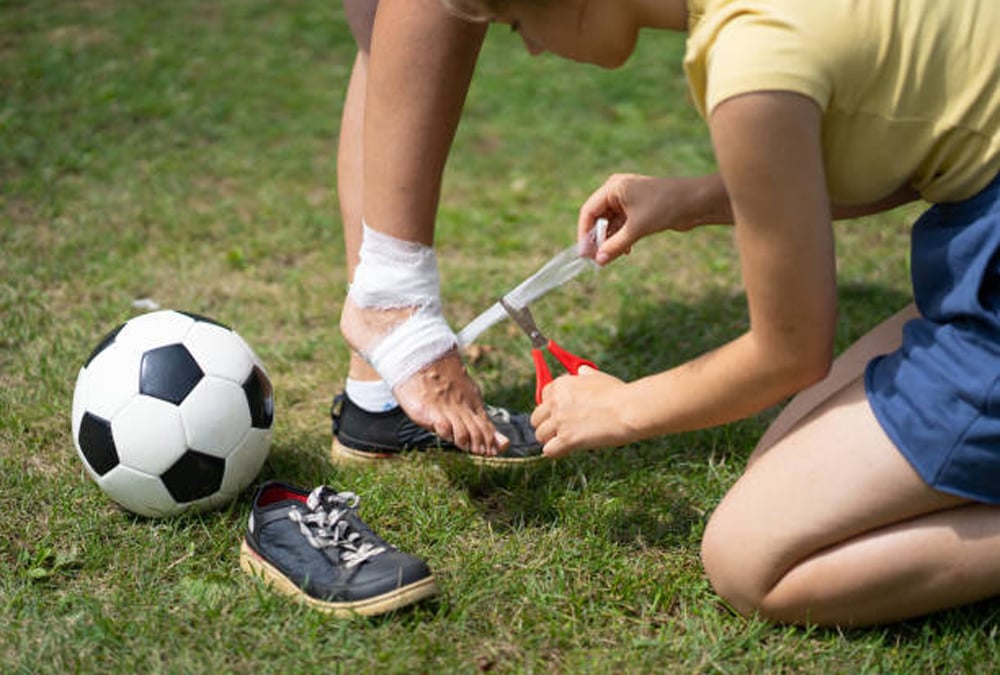 Athletic training taping up ankle for kid